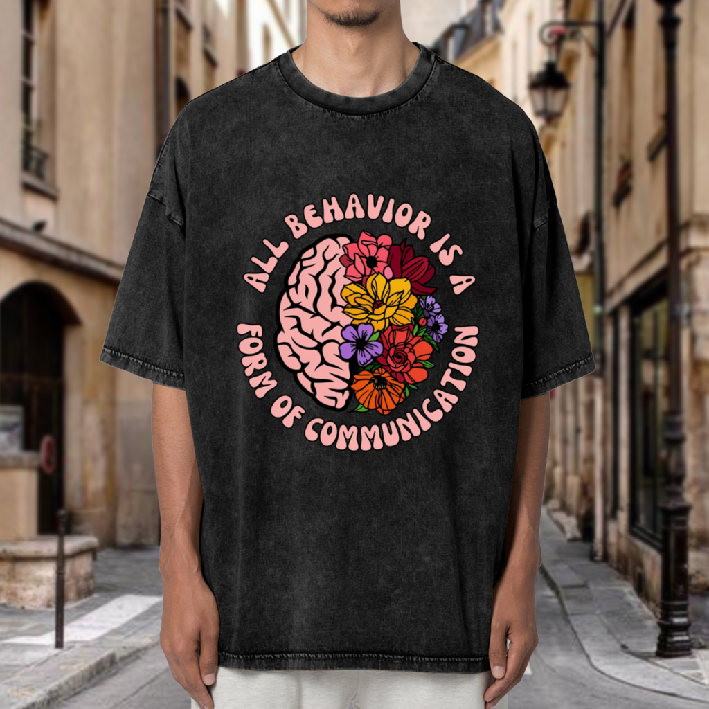 Product image of washed graphic T-shirt featuring 'All Behavior Is Communication' statement design