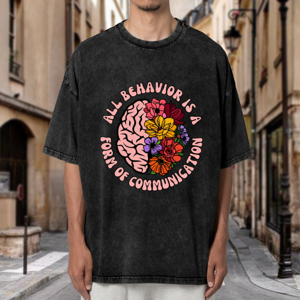 Product image of washed graphic T-shirt featuring 'All Behavior Is Communication' statement design
